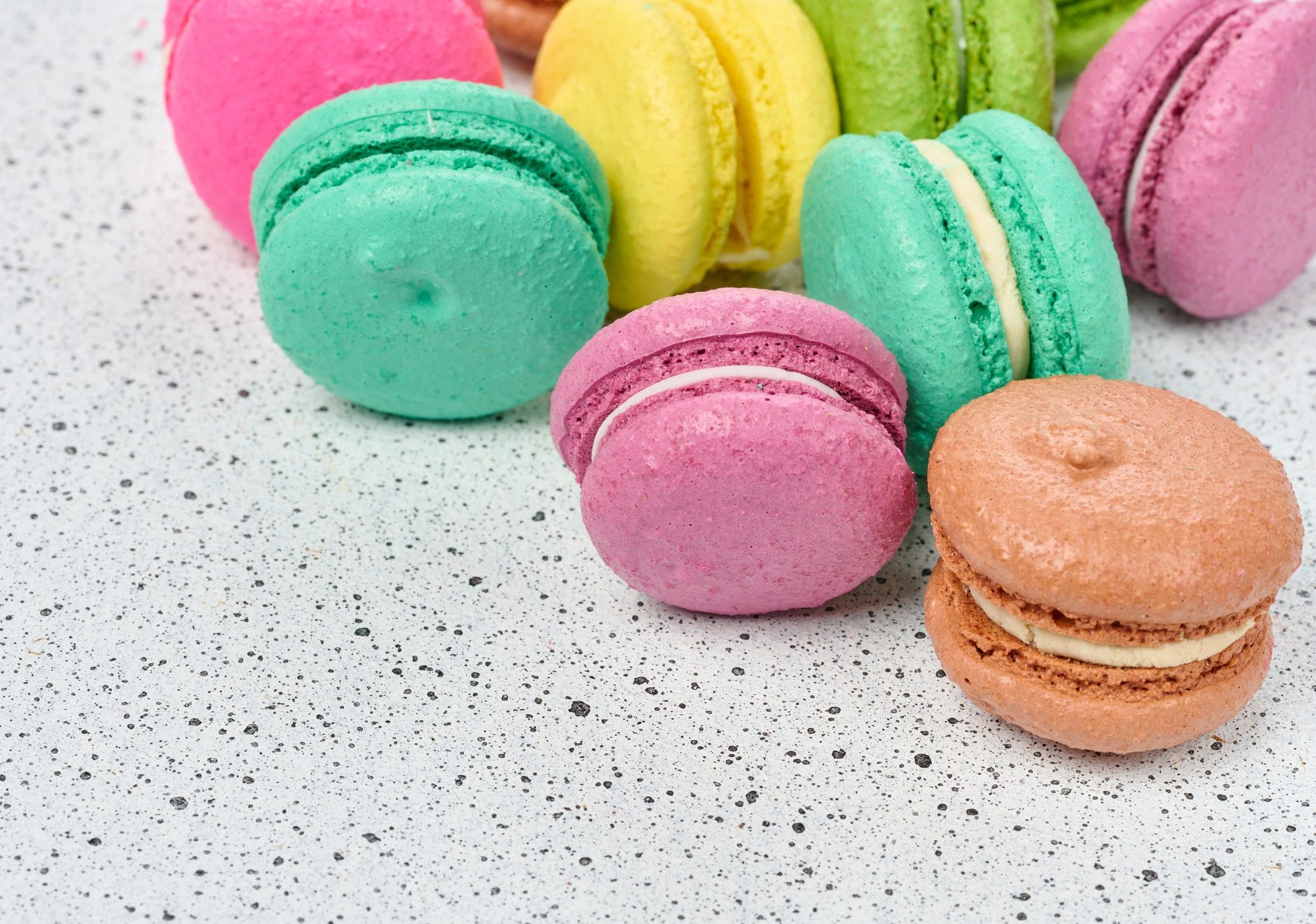 Assorted colorful macarons arranged on a white table